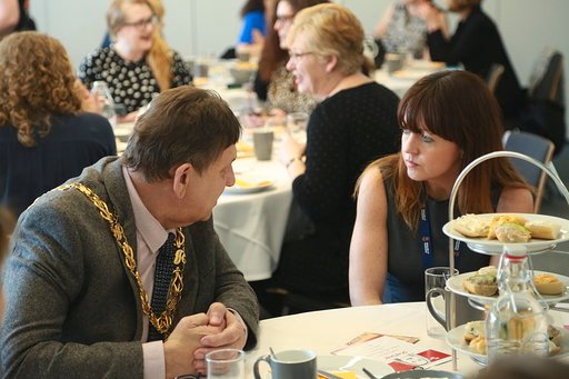 A man is talking and a woman sitting next to him is listening.