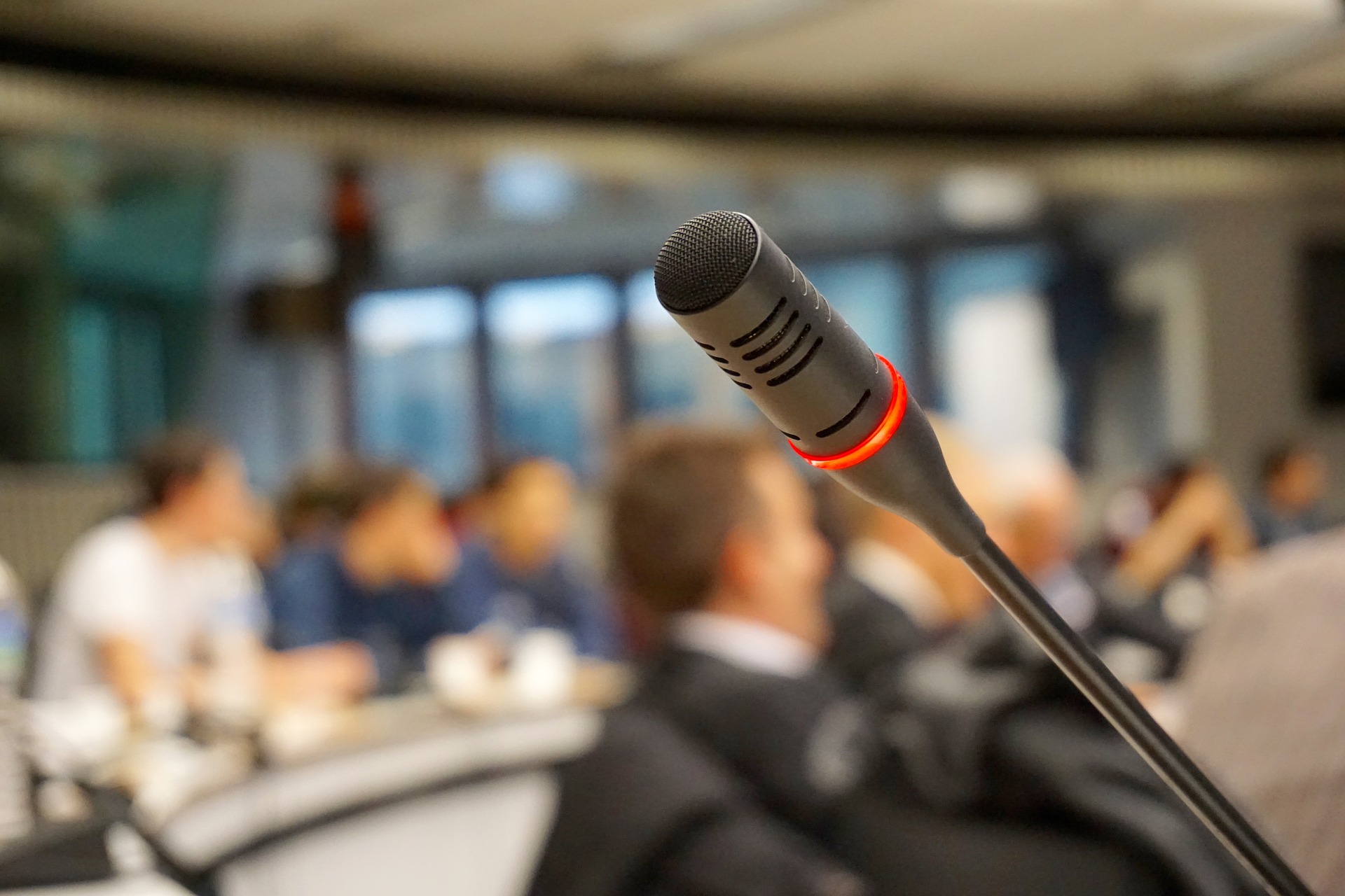 A mic with blurred background that has people focusing in a workshop