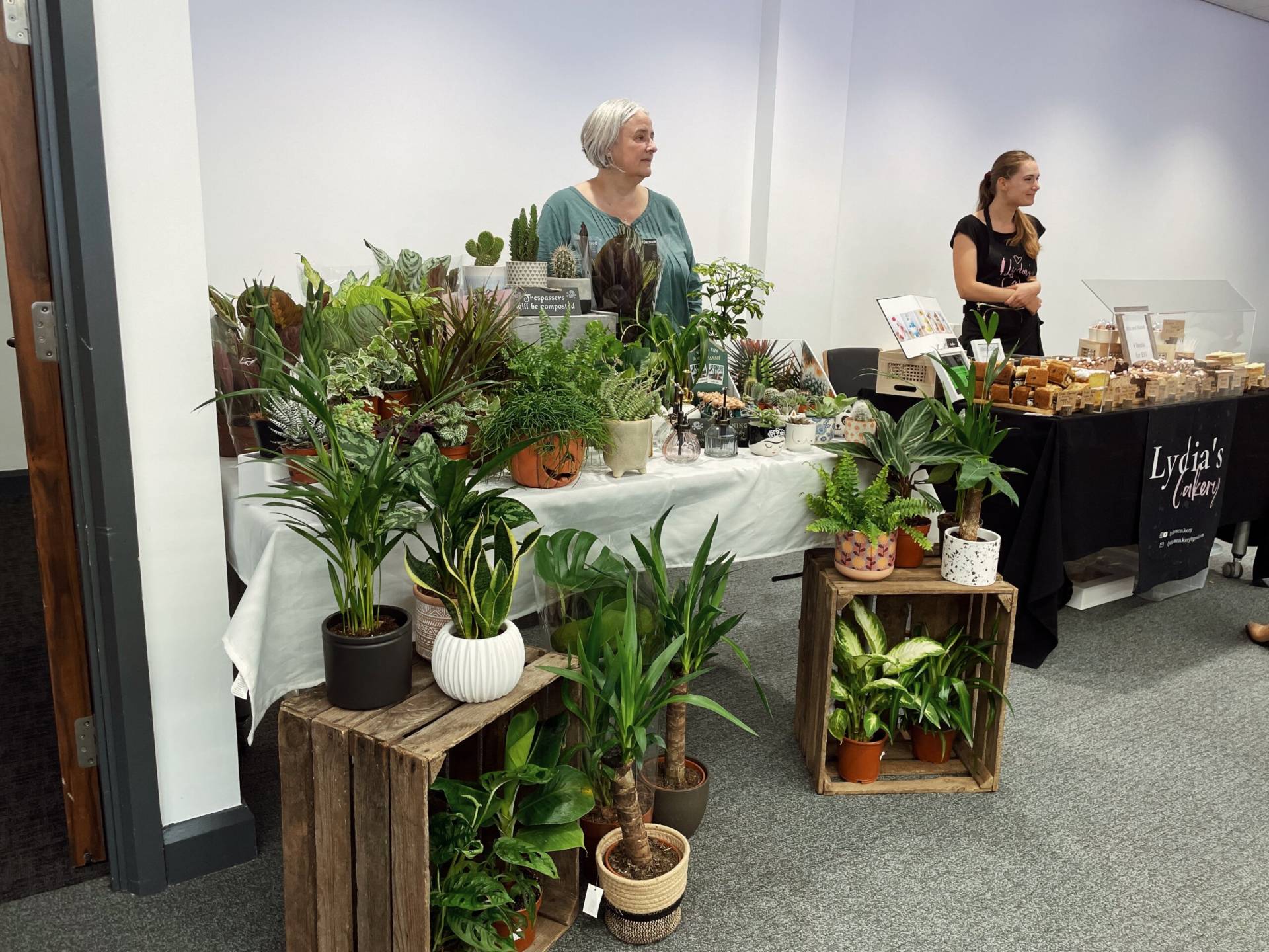 a plant stall and a cake stall in a indoor makers' market